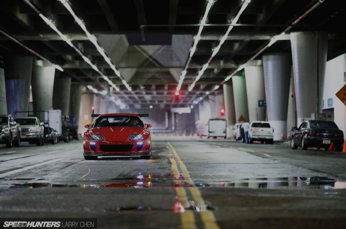 Red performance car in an industrial studio street